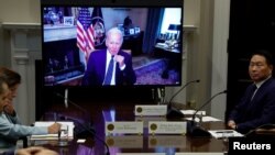 El presidente de EEUU, Joe Biden, es visto a través de una pantalla durante una reunión virtual con una delegación extranjera, en Washington el 26 de julio de 2022.