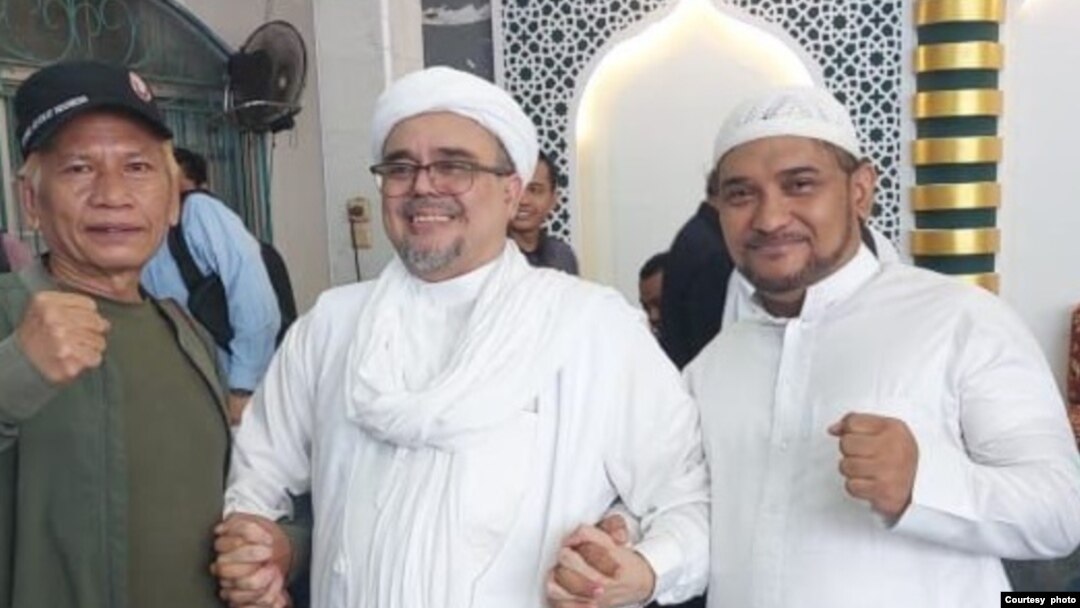 Mantan pemimpin kelompok Front pembela Islam (FPI) Rizieq Shihab (tengah) berpose bersama dengan tokoh pentolan FPI lainnya Novel Bamukmin (kanan) di kediamannya di Jakarta, sesaat setelah dibebaskan pada 20 Juli 2022. (Foto: Courtesy of Novel Bamukmin)