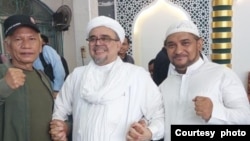 Mantan pemimpin kelompok Front pembela Islam (FPI) Rizieq Shihab (tengah) berpose bersama dengan tokoh pentolan FPI lainnya Novel Bamukmin (kanan) di kediamannya di Jakarta, sesaat setelah dibebaskan pada 20 Juli 2022. (Foto: Courtesy of Novel Bamukmin)