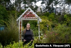 Melissa Kallstrom enjoys the garden the Jefferson Union High School District plans to destroy for more housing in Daly City, July 8, 2022. (AP Photo/Godofredo A. Vásquez)