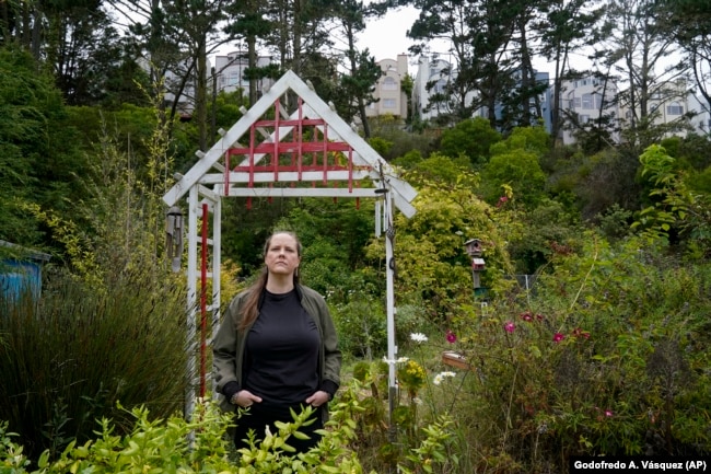 Melissa Kallstrom enjoys the garden the Jefferson Union High School District plans to destroy for more housing in Daly City, July 8, 2022. (AP Photo/Godofredo A. Vásquez)