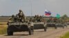 An armored convoy of Russian troops moves through a Russian-held part of Zaporizhzhia region, Ukraine, July 23, 2022. 