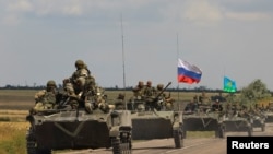 FILE - An armored convoy of Russian troops drives in Russian-held part of Zaporizhzhia region, Ukraine, July 23, 2022. 