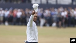 Tiger Woods saluda al público al recibir una de las múltiples ovaciones que le tributaron en la que pudo haber sido la última ronda del Abierto Británico que juega en los campos del Old Course de St. Andrews el 15 de julio del 2022. (AP Photo/Peter Morris)