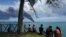 People watch as smoke rises over fuel storage tanks that exploded near Cuba's supertanker port in Matanzas, Cuba, August 7, 2022