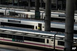 Seorang petugas kebersihan turun dari kereta di stasiun Atocha, Madrid, Spanyol, Senin, 8 Agustus 2022. Perusahaan infrastruktur kereta api Spanyol ADIF melaporkan pencurian sekitar 600 meter kabel serat optik pada malam hari di wilayah Catalonia yang menyebabkan penangguhan layanan kereta api hampir sepanjang Senin pagi. (Foto AP/Paul White)