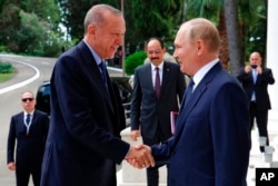 FILE - Russian President Vladimir Putin, right, greets Turkish President Recep Tayyip Erdogan upon his arrival at the Rus sanatorium in the Black Sea resort of Sochi, Russia, Aug. 5, 2022.