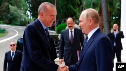 FILE - Russian President Vladimir Putin, right, greets Turkish President Recep Tayyip Erdogan upon his arrival at the Rus sanatorium in the Black Sea resort of Sochi, Russia, Aug. 5, 2022.