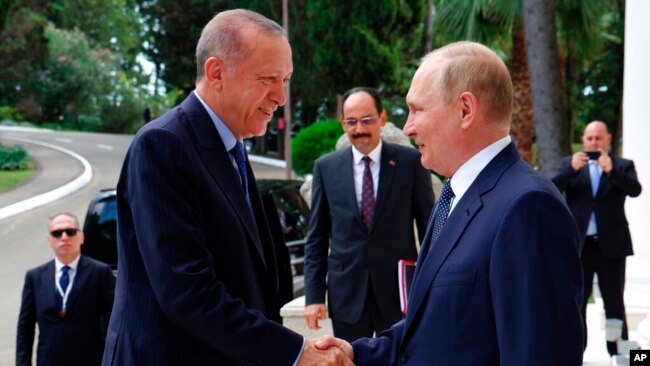 Russian President Vladimir Putin, right, greets Turkish President Recep Tayyip Erdogan upon his arrival at the Rus sanatorium in the Black Sea resort of Sochi, Russia, Aug. 5, 2022.