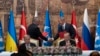 Presiden Turki Recep Tayyip Erdogan dan Sekjen PBB, Antonio Guterres, duduk saat dua perwakilan delegasi Ukraina dan Rusia berjabat tangan selama upacara penandatanganan perjanjian ekspor gandum Ukraina di Istana Dolmabahce, Istanbul, Turki, Jumat, 22 Juli 2022.