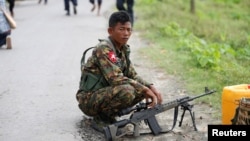 FILE - A soldier guards near a house burnt down during recent violence in Maungdaw, Myanmar Aug. 30, 2017.