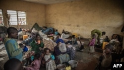 Interno raseljena djeca, zbog nedavnih sukoba između pobunjenika M23 i kongoanskih vojnika, jedu obrok koji su pripremili volonteri, Kongo, maj 2022.