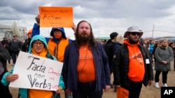 People protest as they await a meeting with Pope Francis at Nakasuk Elementary School Square in Iqaluit, Canada, July 29, 2022.