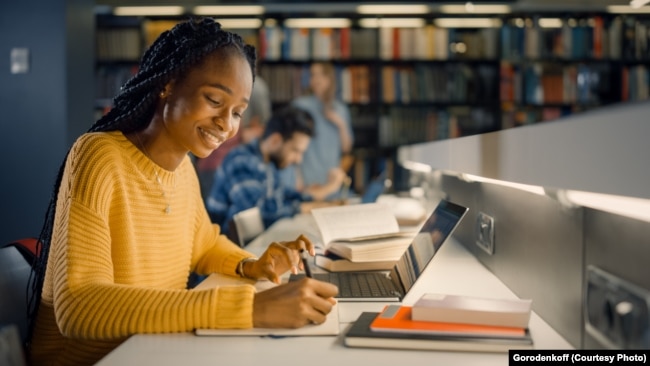 A girl writes notes for a college essay.