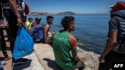 Un migrant marocain, assis après avoir tenté de franchir la frontière entre le Maroc et l'enclave espagnole de Ceuta, le 19 mai 2021.