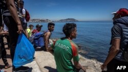 ARCHIVES - Des migrants sur le rivage après avoir tenté de franchir la frontière entre le Maroc et l'enclave espagnole de Ceuta, le 19 mai 2021 à Fnideq.