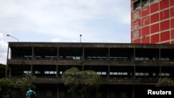 Un hombre camina afuera de la biblioteca de la Universidad Central de Venezuela (UCV), en Caracas, el 6 de octubre de 2020.