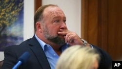 Alex Jones attempts to answer questions about his text messages asked by Mark Bankston, lawyer for Neil Heslin and Scarlett Lewis, during trial at the Travis County Courthouse in Austin, Aug. 3, 2022.