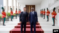 Le président français Emmanuel Macron (à gauche) pose avec le président béninois Patrice Talon (à droite) lors d'une visite officielle au palais présidentiel de Cotonou le 27 juillet 2022.