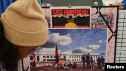 FILE - Gwenda Stanley, an Indigenous Australian of Gomeroi descent, organizes belongings in front of a historical image of the Aboriginal Tent Embassy, in Canberra, Australia, May 4, 2022.