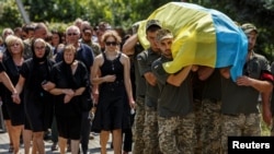 Ukrainian servicemen carry a coffin with the body of their brother-in-arms Vitalii Petiushko, who was recently killed in a fight with Russian troops, as Russia's attack on Ukraine continues, during a funeral ceremony in Uzhhorod, Ukraine, on August 8, 2022. 