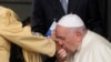 El papa Francisco besa la mano de una mujer indígena canadiense cuando llega al aeropuerto internacional de Edmonton, Canadá, el domingo 24 de julio de 2022.