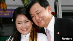 FILE - Ousted Thai Prime Minister Thaksin Shinawatra, who was deposed in a bloodless 2006 coup, poses with his daughter Paetongtarn during her graduation day at a Bangkok university, July 10, 2008. 