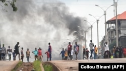 FILE: Protesters block roads and hurl rocks in Conakry on July 28, 2022, after authorities prevented supporters of the opposition party, National Front for the Defense of the Constitution (FNDC), from gathering in the streets for a peaceful march. 