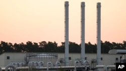 FILE - The sun rises behind the landfall facility of the Nord Stream 1 Baltic Sea pipeline and the transfer station of the OPAL gas pipeline, the Baltic Sea Pipeline Link, in Lubmin, Germany, July 21, 2022. 