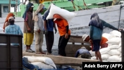Para pekerja memuat karung pupuk di sebuah pelabuhan di Jakarta, 7 Desember 2007. (Foto: AFP/Adek Berry)
