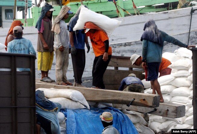 Pekerja memuat karung pupuk di sebuah pelabuhan di Jakarta, 7 Desember 2007. (Foto: AFP/Adek Berry)