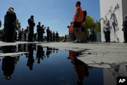 FILE - Police officers guard climate activists with the group Uprising of the Last Generation after they threw black paint on the wall of the chancellery in Berlin, Germany, June 22, 2022.