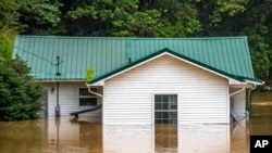 Las casas se inundan en Lost Creek, Ky., el jueves 28 de julio de 2022. Las fuertes lluvias han provocado inundaciones repentinas y deslizamientos de tierra mientras las tormentas golpean partes del centro de los Apalaches.