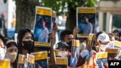 Sekelompok aktivis plakat bergambar foto Toru Kubota, warga negara Jepang yang ditahan di Myanmar, dalam aksi unjuk rasa di depan Kementerian Luar Negeri di Tokyo, 31 Juli 2022. (Philip FONG / AFP)