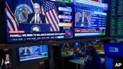FILE - As traders work and watch, a news conference held by Federal Reserve Chair Jerome Powell is displayed at the New York Stock Exchange in New York, July 27, 2022. 