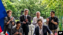 Secretary of State Antony Blinken applauds as U.S. Trade and Development Agency Director Enoh Ebong and Aboitiz Power Vice President of Reusables David Aboitiz sign a USTDA Offshore Wind Grant at Ayala Triangle Gardens in Manila, Philippines, Saturday, Aug. 6, 2022.