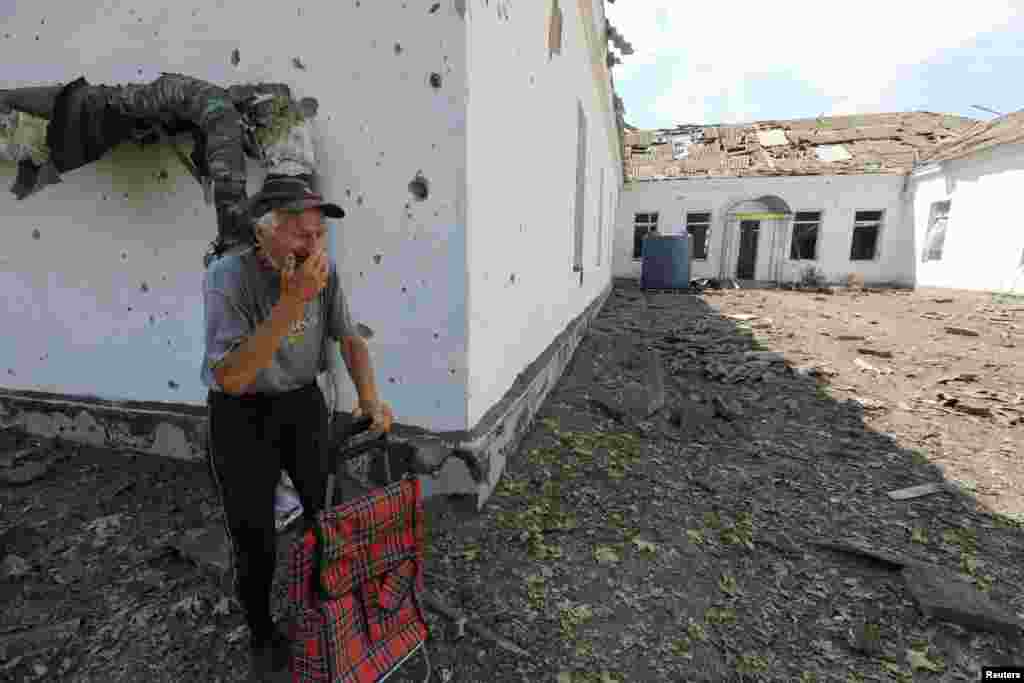 A local resident reacts near a school building damaged by a Russian missile strike, as Russia's attack on Ukraine continues, in Mykolaiv, Ukraine.