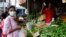 FILE - A vendor sells vegetables to a customer amid the rampant food inflation, amid Sri Lanka's economic crisis, in Colombo, Sri Lanka, July 29 , 2022.