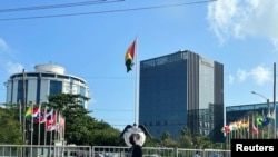 Una mujer camina por la plaza central de Georgetown. Al fondo se ve el Pegasus Suites Corporate Center, un edificio de 12 pisos de altura que es el más alto del país, en Georgetown, Guyana, el 17 de febrero de 2022.