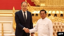 Russian Foreign Minister Sergei Lavrov (R) shakes hands with Myanmar Min Aung Hlaing, Senior General and Chairman of the State Administration Council in Naypyidaw, on August 3, 2022. (Photo by HANDOUT / RUSSIAN FOREIGN MINISTRY / AFP)