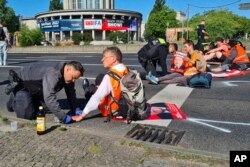 Ernst Hörmann, 72, wird am Montag, 11. Juli 2022, bei einem Protest im Rahmen des Aufstands der letzten Generation in Berlin die Hand vom Boden abgehoben.