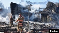 Firefighters work in a residential area damaged by a Russian missile strike in the settlement of Zatoka, Odesa region, Ukraine July 26, 2022, in this photo provided by the State Emergency Service of Ukraine.