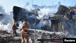 Firefighters work in a residential area damaged by a Russian missile strike in the settlement of Zatoka, Odesa region, Ukraine July 26, 2022, in this photo provided by the State Emergency Service of Ukraine.