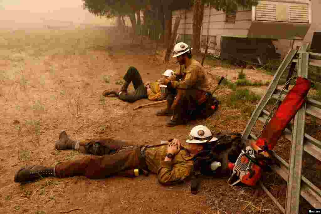Klamath Interagency Hotshot firefighters rest while waiting for a new assignment as the McKinney Fire burns near Yreka, California, July 31, 2022.