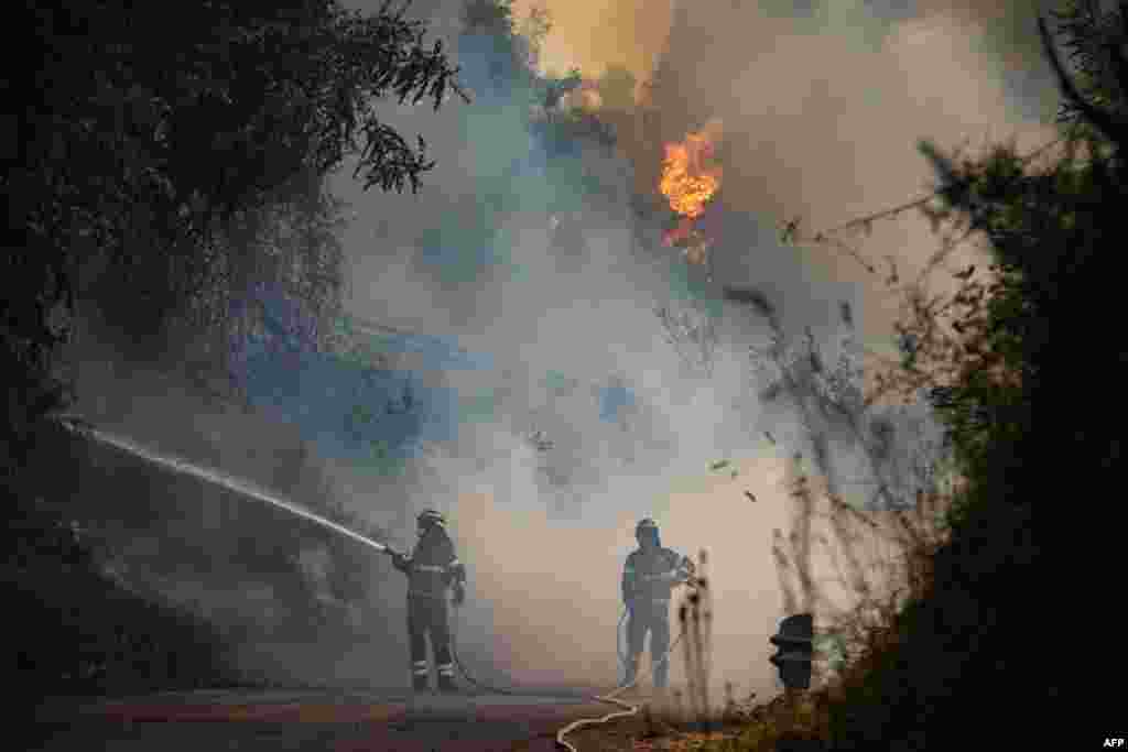 Firefighters try to put down a fire near the city of Massarosa, central Italy.