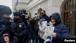Полицейские разговаривают со сторонниками правозащитной группы «Мемориал», собравшихся у здания Верховного суда России в Москве, где было принято решение о закрытии организации 14 декабря 2021 года