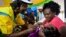 FILE - A health worker vaccinates a child against malaria in Homabay County, western Kenya, Sept.13, 2019. Malaria hospitalizations and deaths fell the vaccine's pilot program countries of Kenya, Ghana and Malawi and a mass rollout of the vaccine is underway.