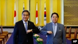 South Korean Foreign Minister Park Jin, left, and Japanese counterpart Yoshimasa Hayashi pose for a photo as they bump elbows to greet each other before their talks in Tokyo, Monday, July 18, 2022. (Kim Kyung-Hoon/Pool Photo via AP)