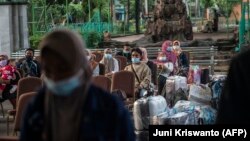 Buruh migran yang kembali dari Malaysia dan Singapura menunggu pemeriksaan COVID-19 di Surabaya pada 28 April 2021. Situasi pandemi COVID-19 dunia yang mulai membaik belum berdampak signifikan terhadap nasib Calon Pekerja Migran Indonesia (CPMI). (Foto: AFP/Juni Kriswanto)