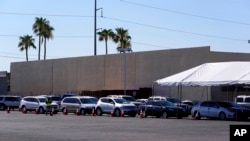 Dozens of vehicles line up to get provisions at St. Mary's Food Bank on June 29, 2022, in Phoenix. Long lines are back at food banks around the U.S., as Americans overwhelmed by inflation and higher gas prices seek help feeding their families.